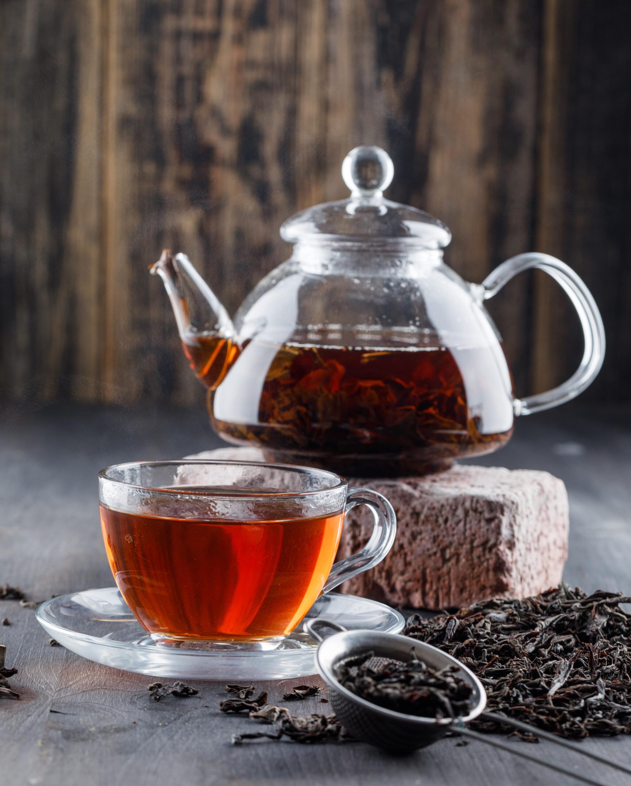 black-tea-teapot-cup-with-dry-tea-brick-side-view-wooden-surface-min